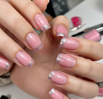 A soft pink base with a light silver glitter fade at the tips, very subtle and sparkly