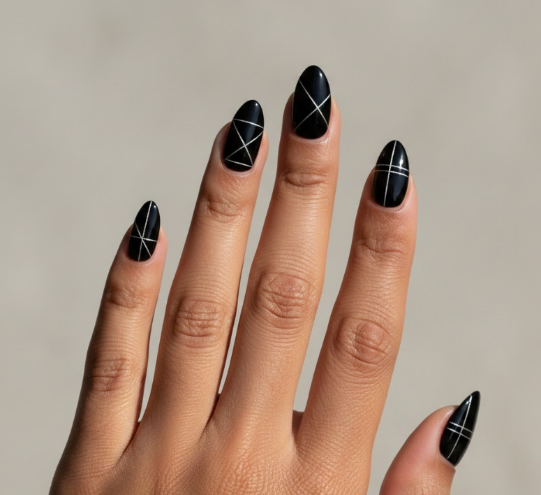 Black nails with sharp geometric lines and small hearts, edgy and modern