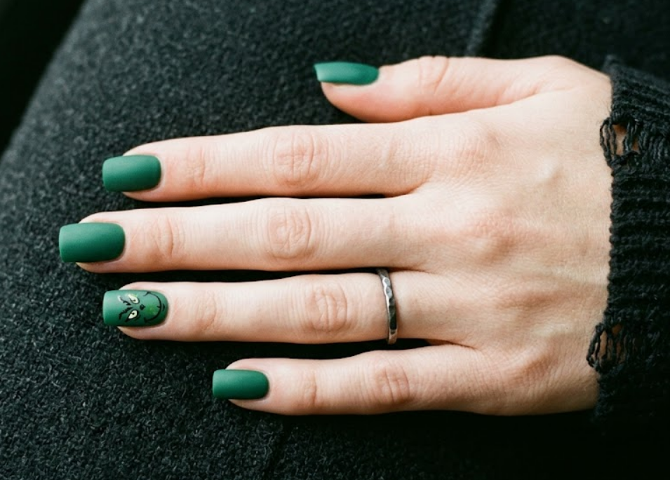 Matte green base with a small subtle Grinch accent on one nail.