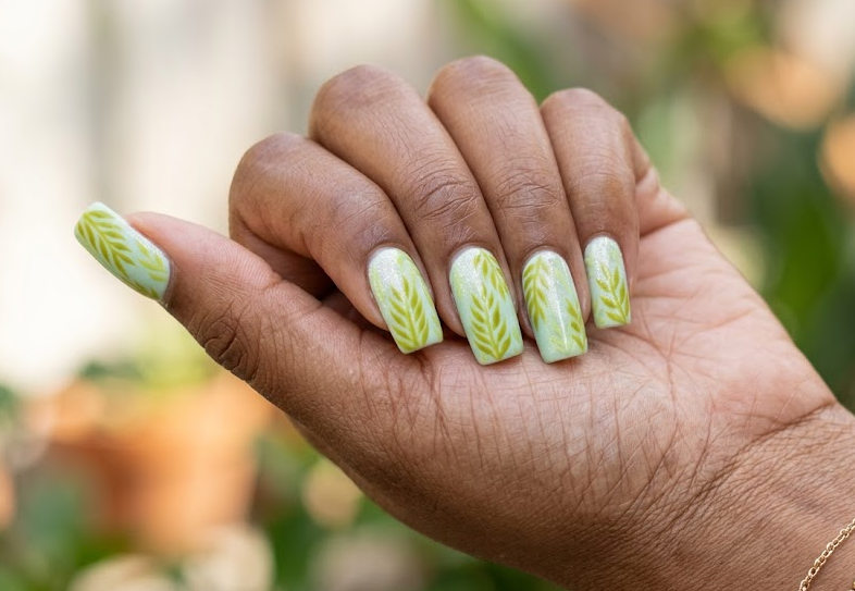 Apricot Tree – Stiletto shaped nails: Soft peach base, light green oversized apricot leaves, matte finish, fresh spring vibe.
