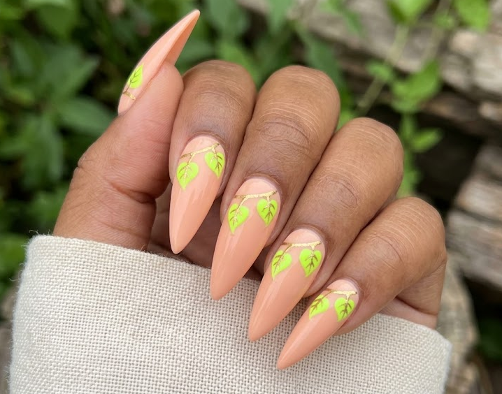 Pothos – Stiletto shaped nails: Soft peach base, neon green heart-shaped pothos leafs near cuticle, tiny gold veins, playful nails.