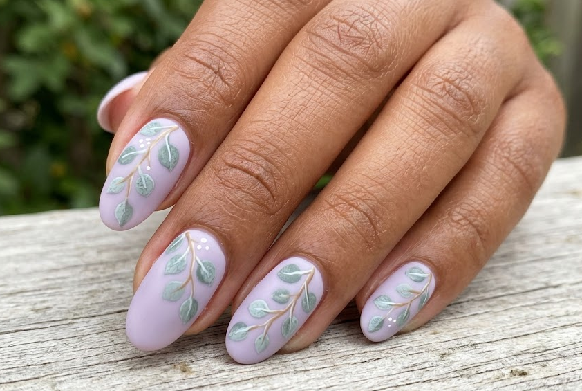 Eucalyptus – Oval shaped nails: Soft lilac base, dusty silver-green round eucalyptus leafs trailing, elegant summer nails.
