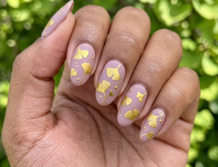 Ginkgo Biloba – Oval shaped nails: Mauve base, golden fan-shaped ginkgo leafs scattered, matte finish, autumn nails.