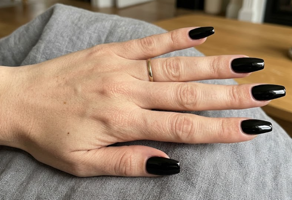 A hand featuring sleek black nails colors to help user to choose the perfect color nails for a sophisticated and edgy appearance