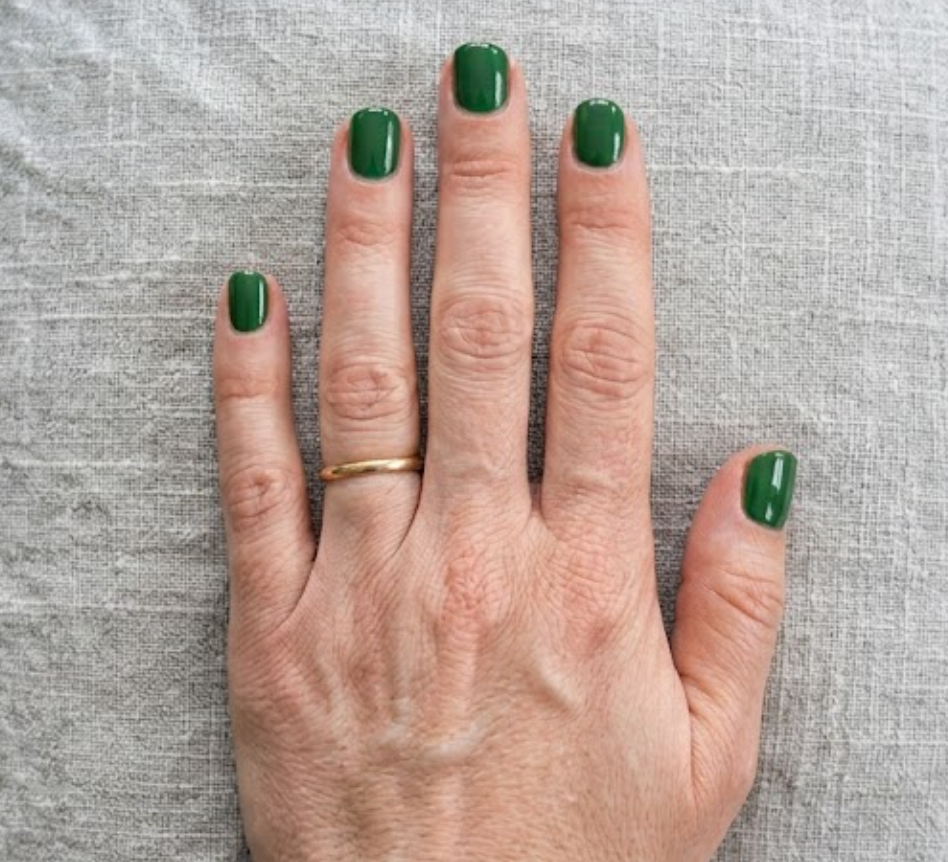 A hand featuring earthy green nails colors to help user to choose the perfect color nails for a balanced and unique look.