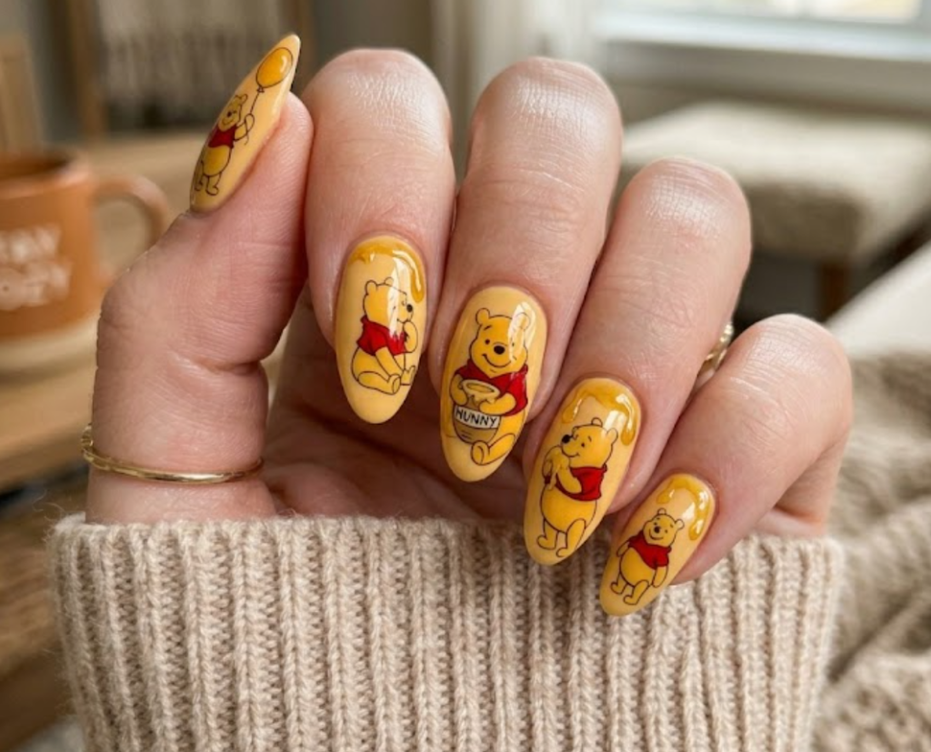 This nail design shows Winnie the Pooh holding a honey pot