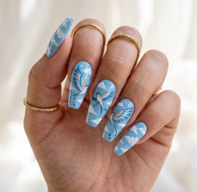 In this picture, medium coffin nails show sky-blue kite bird nail designs with cloud patterns.