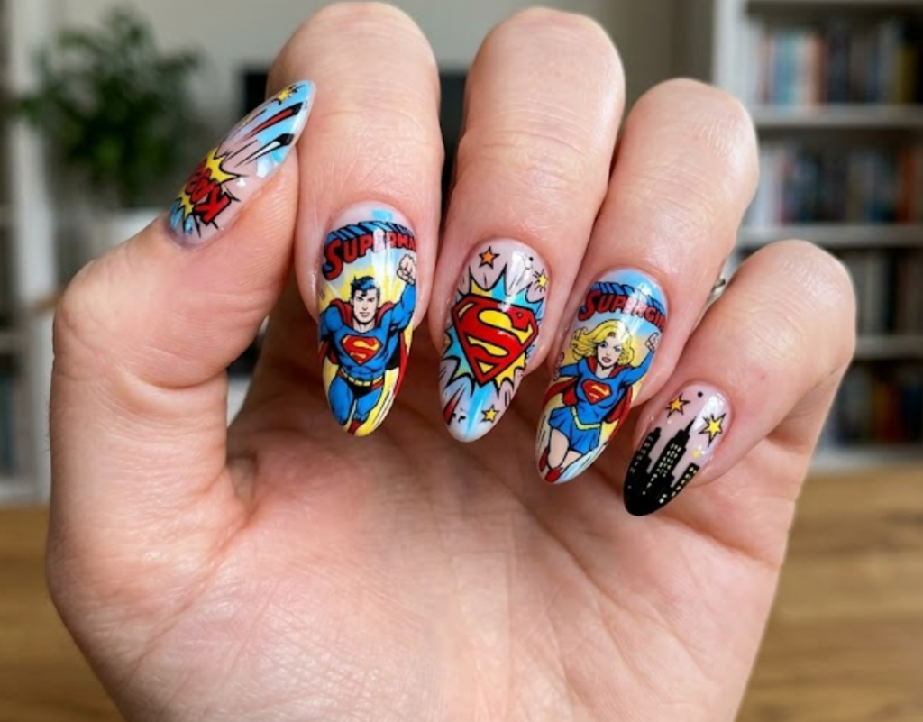A woman’s hand showing Supergirl and Superman flying together with matching red and blue S logos.