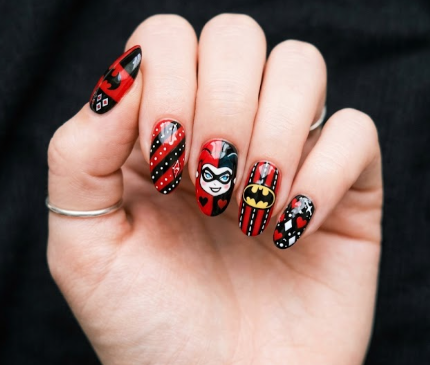 Full hand Batman Harley Quinn red and black diamond pattern nails with playful comic details on a simple background