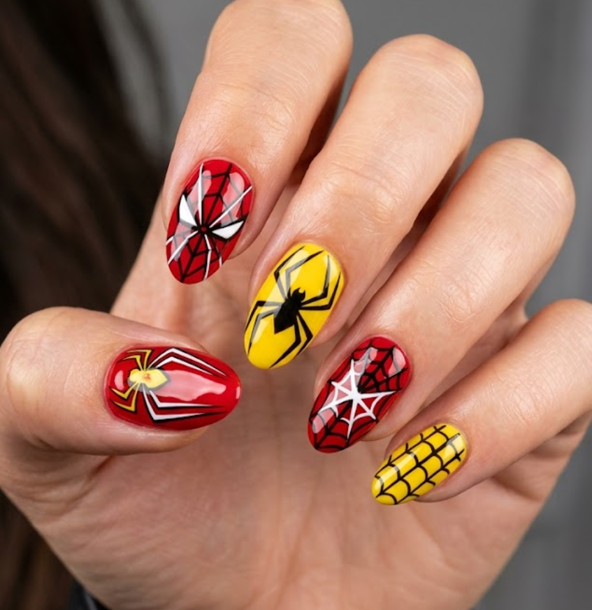 Spider-Woman themed nail art with bold red nails, yellow accents, and geometric spider web grid design in close-up view.