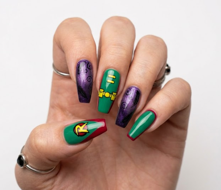 Coffin shaped nails showing a Teen Titans design split between Raven's dark purple smoky style and Robin's green and red suit colors with a small R logo.