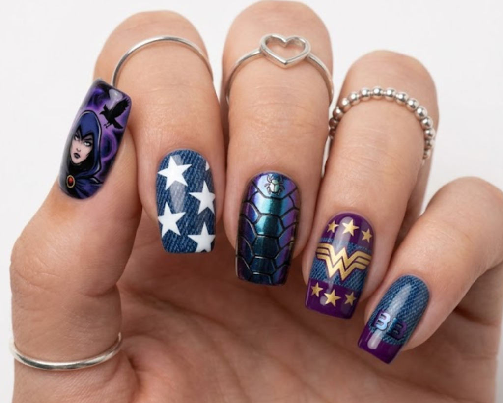 Squoval nails mixing Wonder Girl's white stars over denim texture with Blue Beetle's shiny iridescent alien shell foil and Raven's purple base.