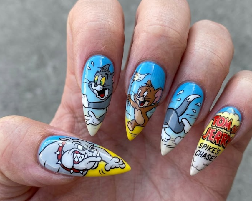 Stiletto-shaped Spike and Tom cartoon nails with bold action scenes and glossy finish.