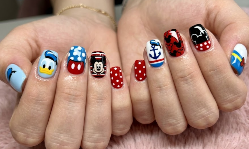 Minnie Mouse inspired nail art with red bows, polka dots, glitter accents, and a cute feminine style.