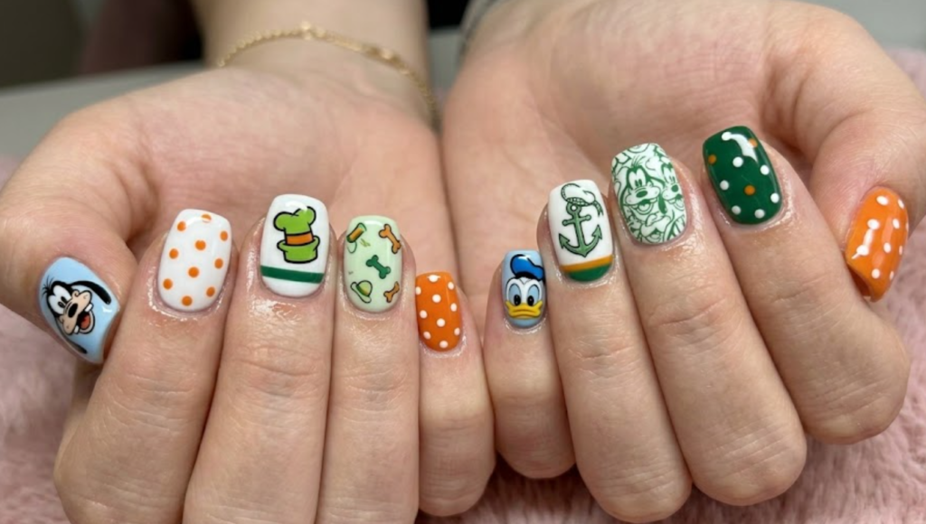 Goofy inspired orange and green nail design with funny expressions and playful cartoon character details.