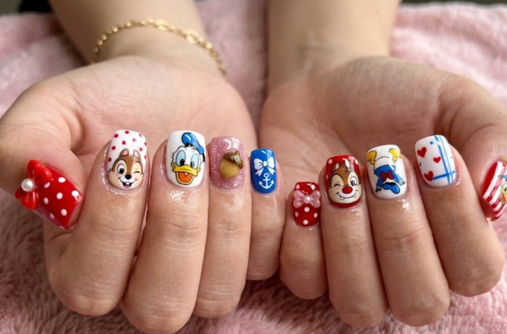 Dale inspired playful nail design with red nose accents, cheerful expressions, and cartoon-style details.