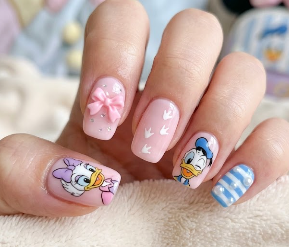 Webby Duck inspired pastel pink nail art featuring bows, duck footprints, and cute feminine details.