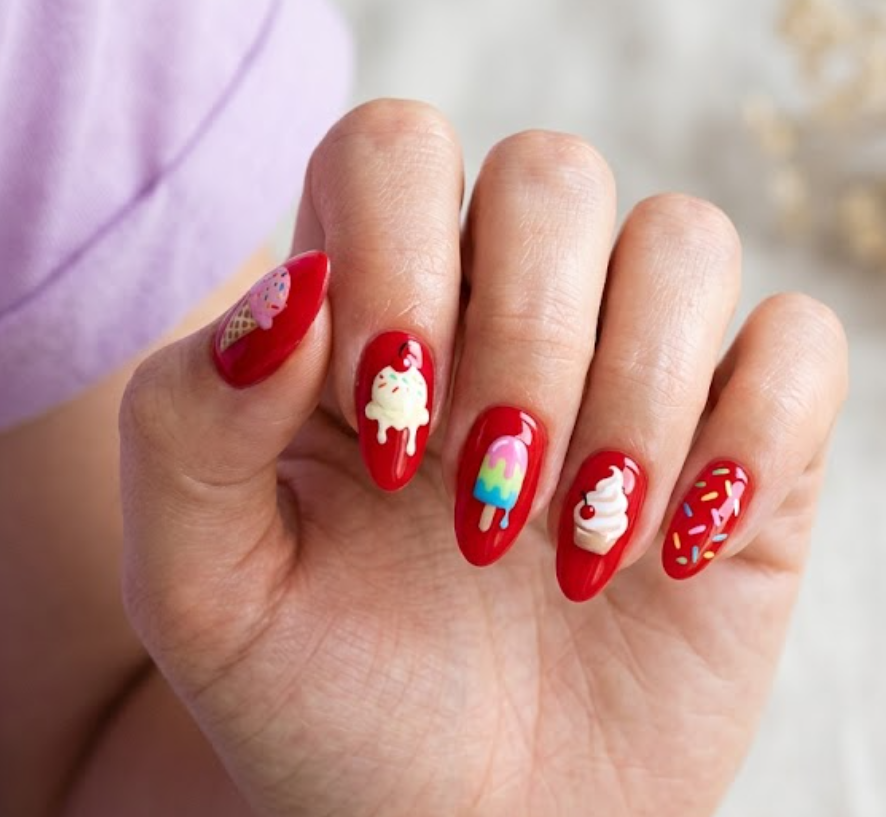 This image shows playful red summer nails inspired by an ice cream date on a female hand.
