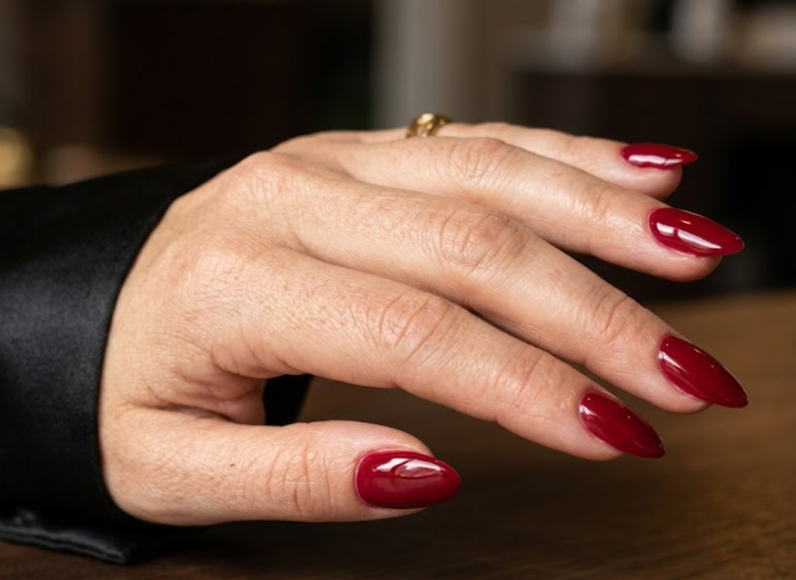 This image shows luxurious glossy red nails inspired by celebrity red carpet style on a female hand. This image shows luxurious glossy red nails inspired by celebrity red carpet style on a female hand.