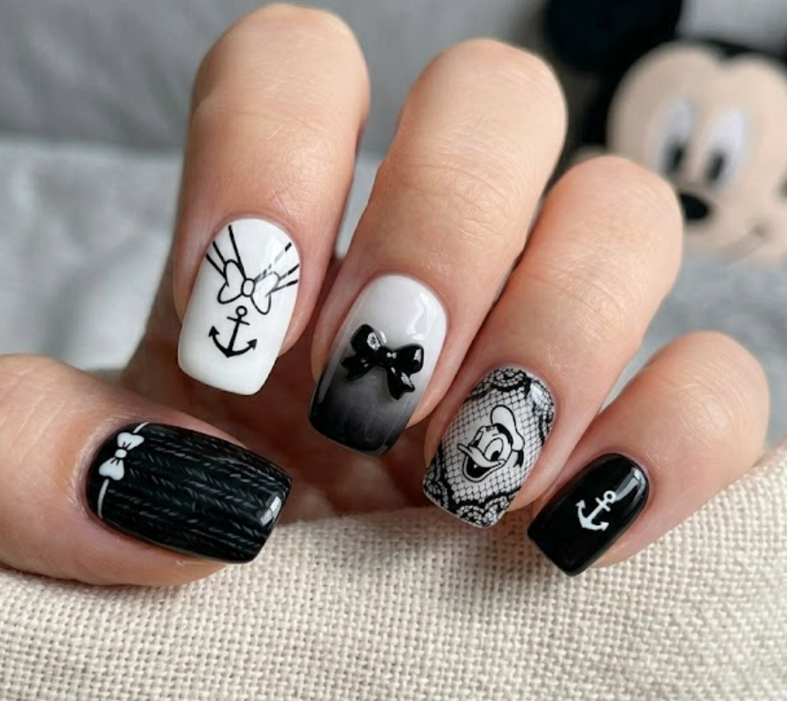 Mrs. Beakley inspired black and white nail art with elegant patterns and a sophisticated cartoon look.