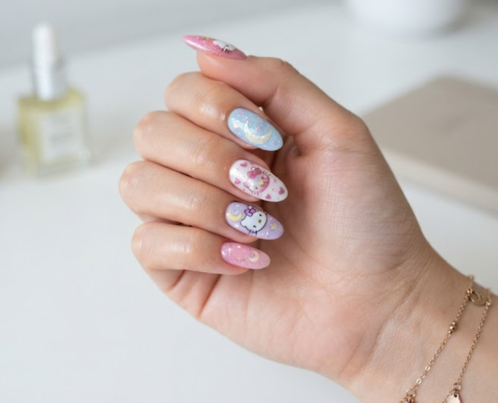 Close-up of Hello Kitty silhouette nail art with pastel crescent moon details.