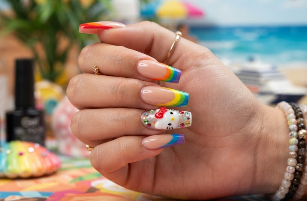 Close-up shot of Hello Kitty nails with vibrant rainbow French tips.