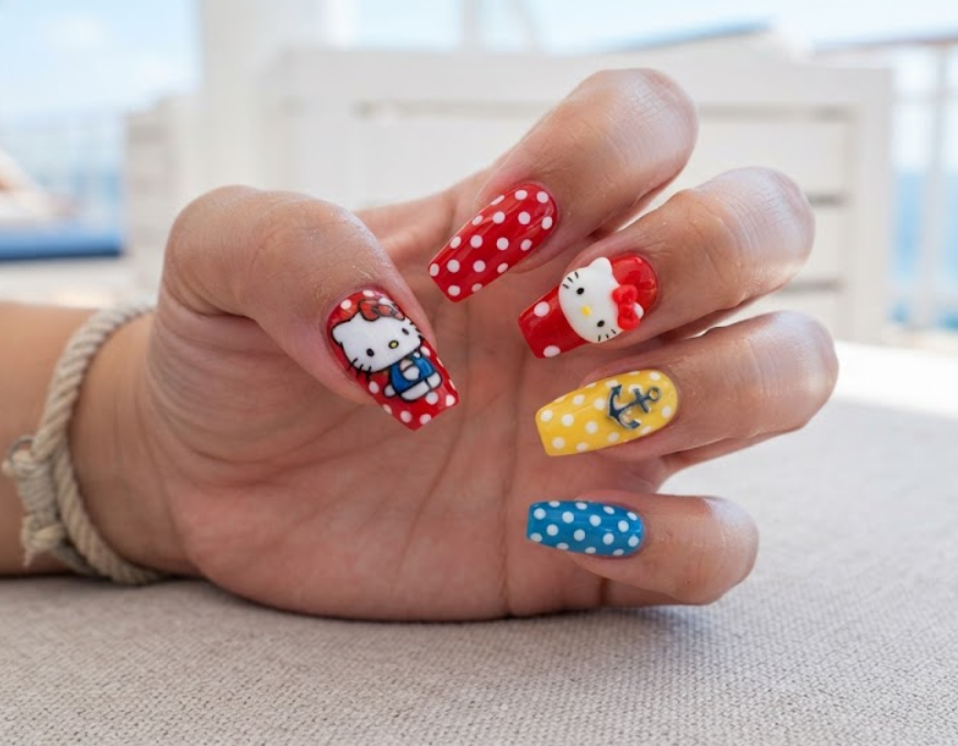 Full hand close-up of retro Hello Kitty nail art with polka dot patterns.