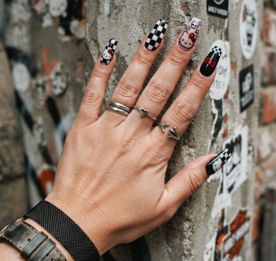 Edgy Hello Kitty nail design close-up with black and white checkerboard tiles.