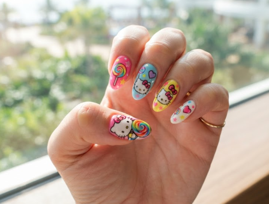 Close-up shot of Hello Kitty nails featuring cheerful lollipop motifs.