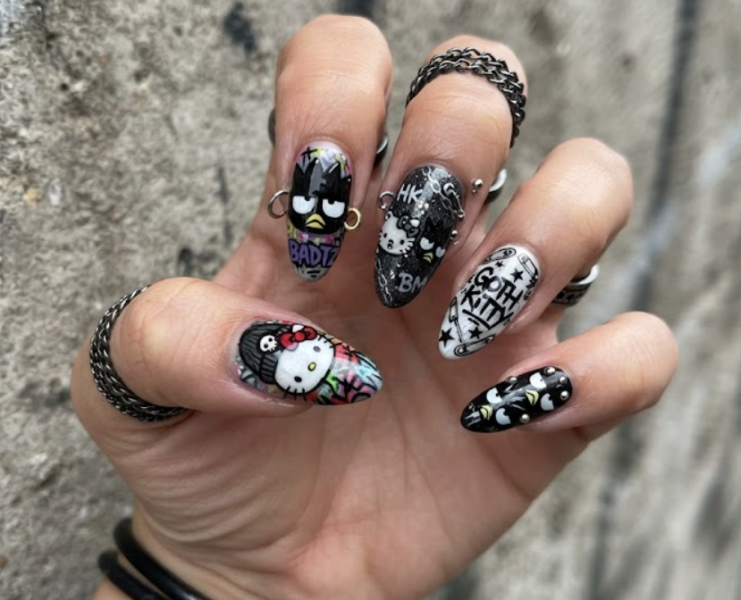 Urban style Hello Kitty and Badtz-Maru themed nail art close-up.