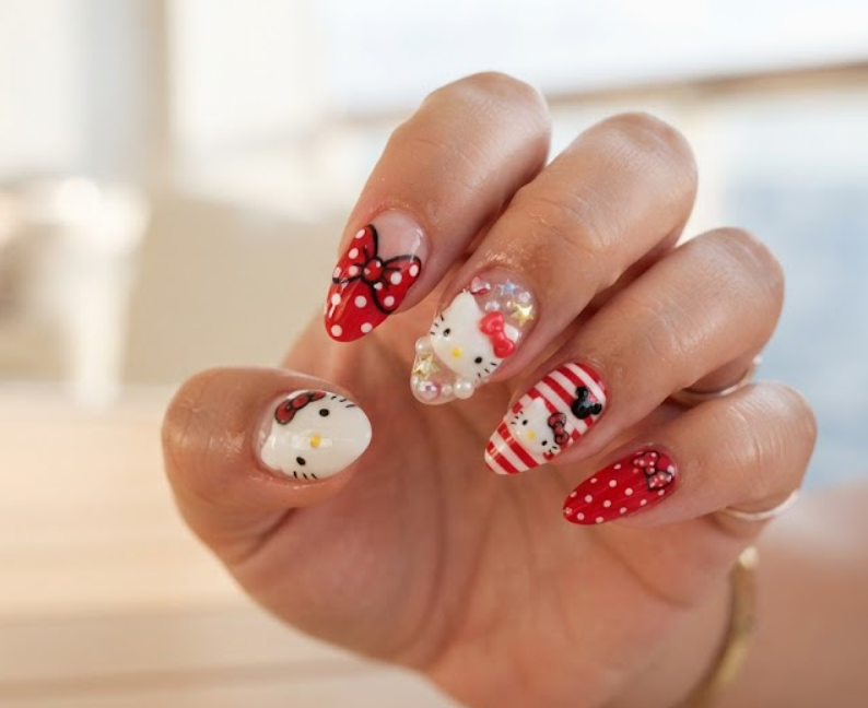 Hello Kitty and Mickey Mouse bow crossover nail design close-up.