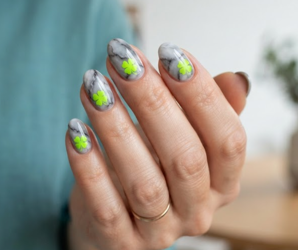 In this image, a dramatic 4-Leaf Clover Nail highlights a smokey marble base and a bright lime green clover with a teal shirt.
