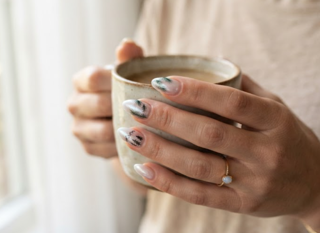 in this image real hands showcase frosted pine needle glaze camp nail art. camp inspired nail design