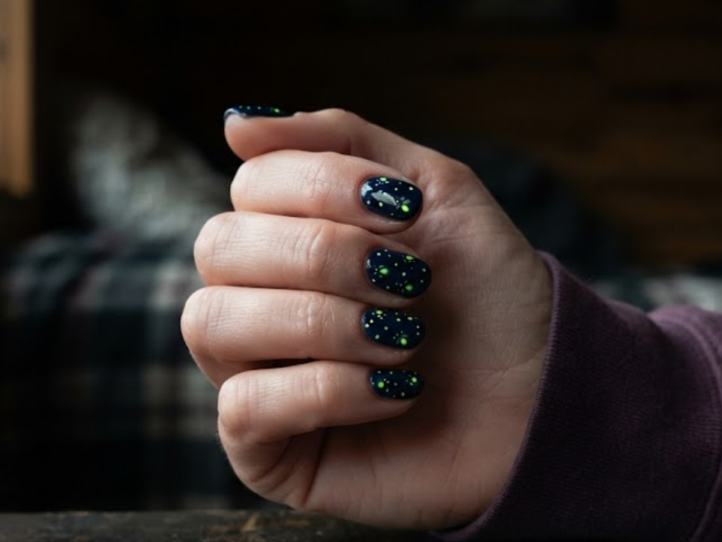 in this image real hands feature firefly glow-in-the-dark camp nail art. camp inspired nail design