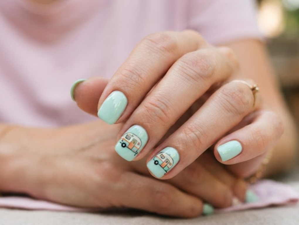 in this image real hands display a retro camper van pastel pop nail design. camp inspired nail design