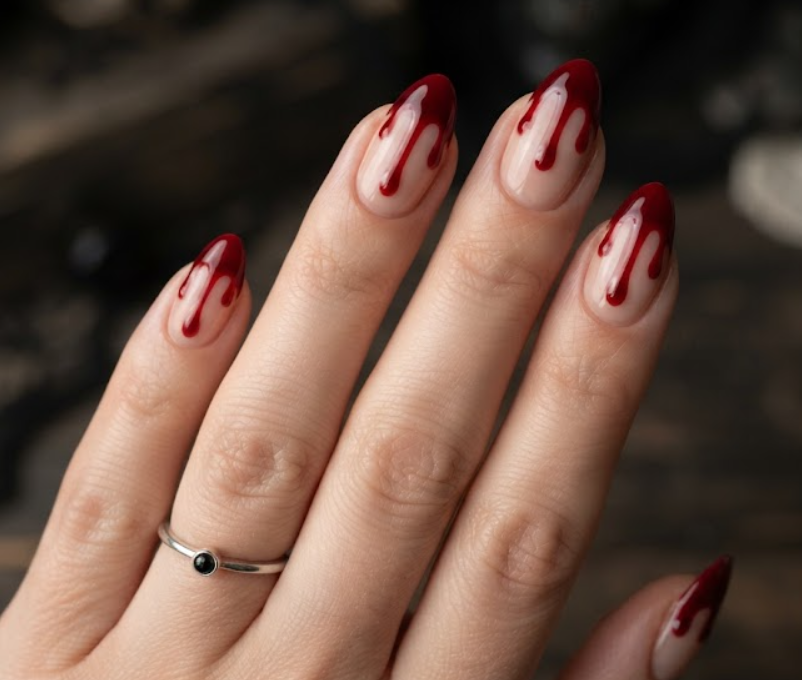 In this photo, classic French tips get a creepy makeover with realistic blood red drips along the nail edges.