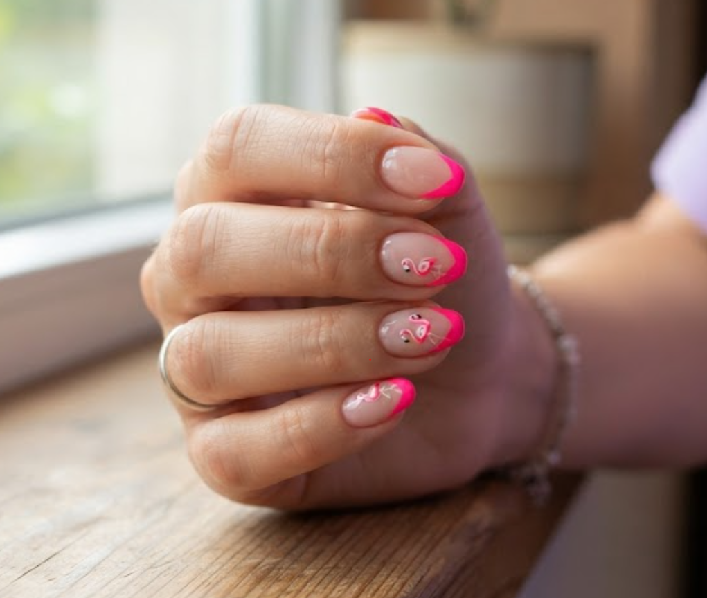 In this image, a woman in a lavender shirt presents natural round nails with a nude pink base and neon pink diagonal French tips.