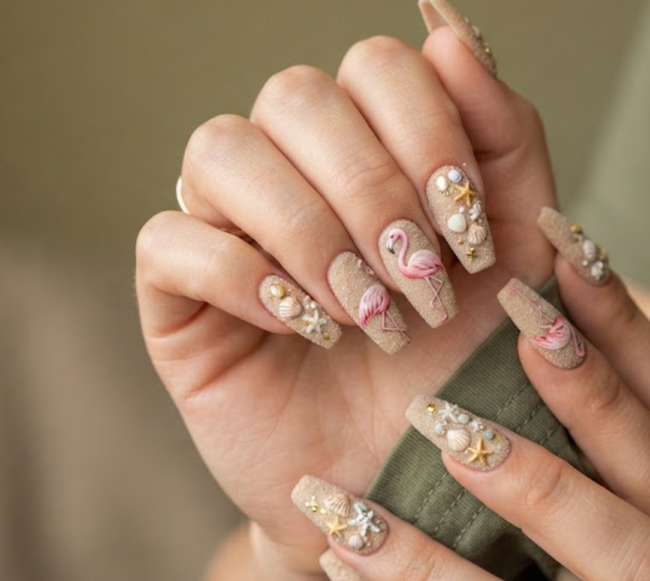 In this image, a woman in an olive green shirt features long coffin nails with a sandy nude matte base and realistic flamingo.