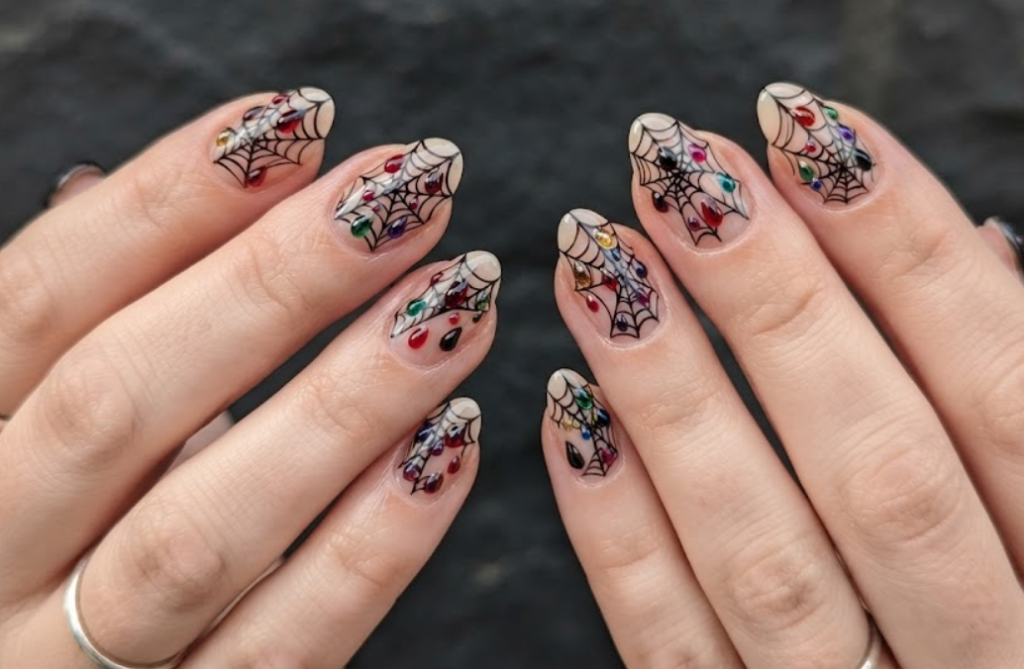 In this photo, black spider webs and fresh blood drops create a classic Halloween-inspired manicure.