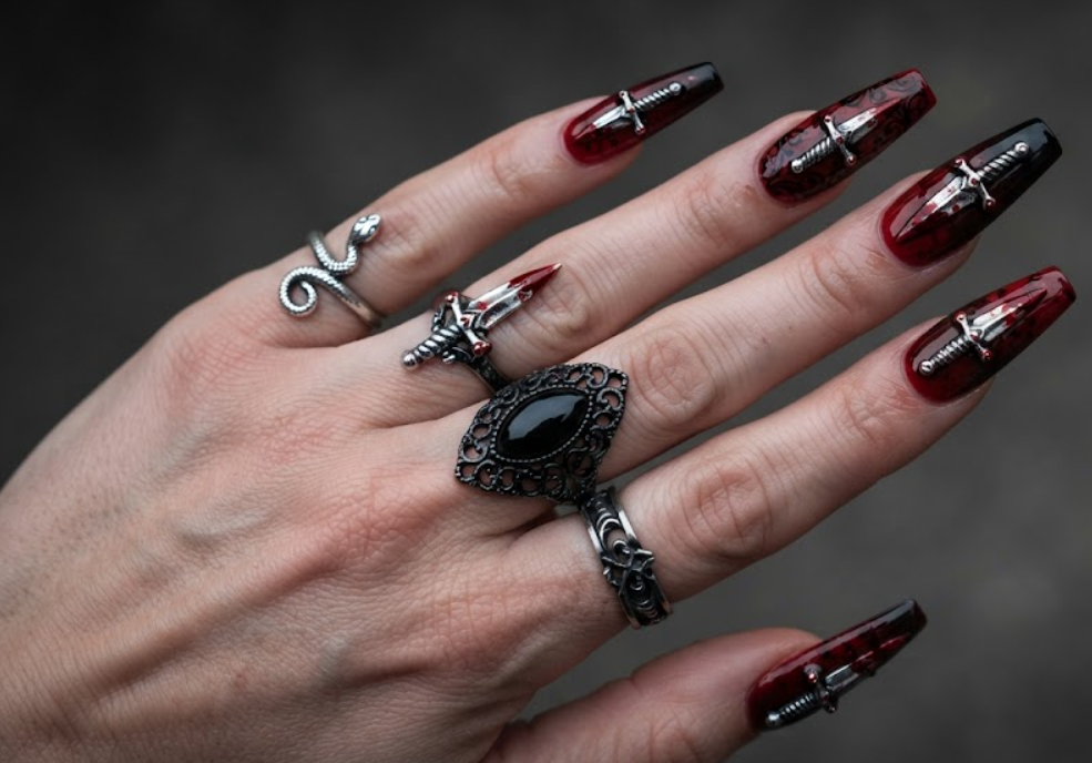 In this photo, tiny silver daggers with blood stains create a fierce and edgy horror-inspired nail design.