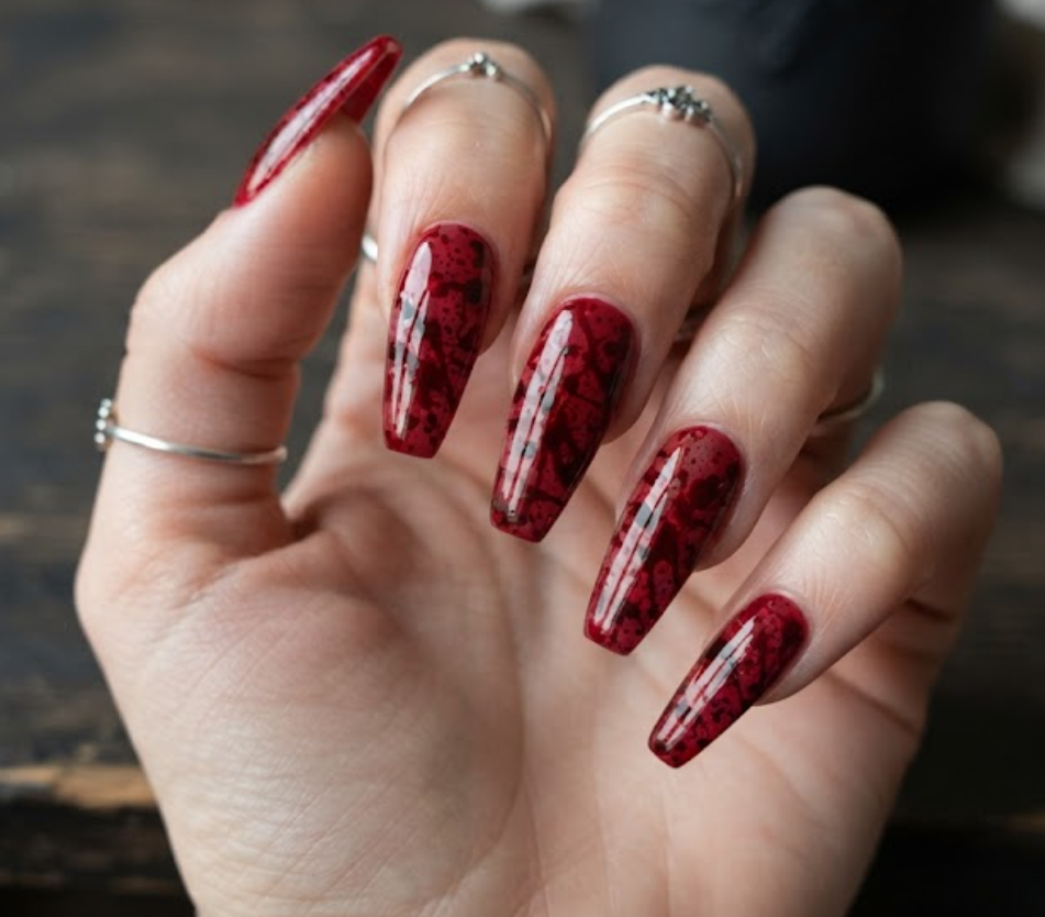In this photo, long coffin-shaped nails feature dramatic blood splatter artwork for a striking Halloween manicure.