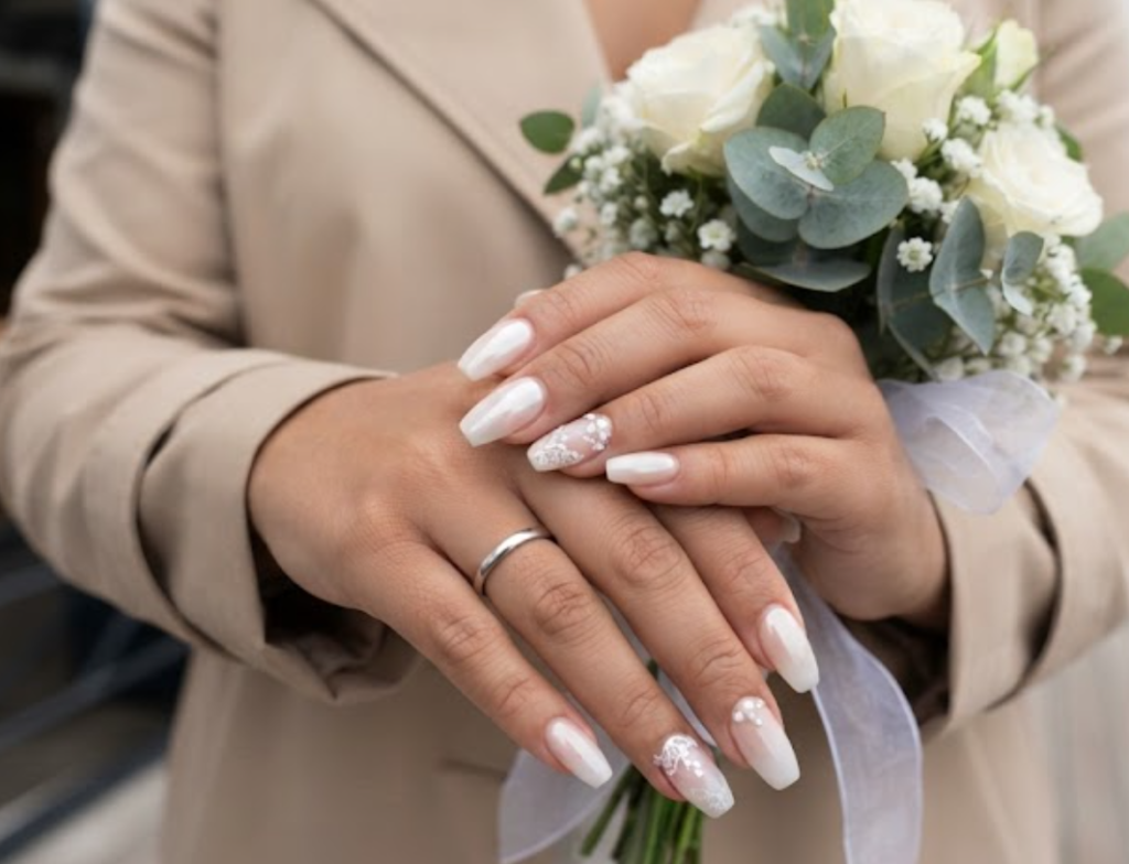 In this image, cruise wedding nails highlight short coffin soft nude-to-white ombré nails with pearl topcoat, worn by hands in a beige trench coat.