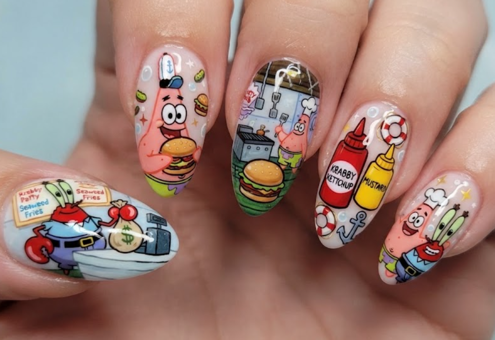 In this photo, Patrick Star and Mr. Krabs appear on a Krusty Krab-inspired nail set featuring tiny Krabby Patties, chef hats, and restaurant decorations.