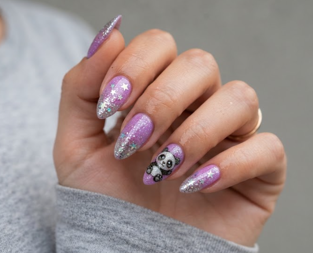 In this image, short square-shaped natural nails with a groovy mustard yellow base are shown. One nail displays a 70s retro-styled panda face. Others feature wavy 70s lines, brown-and-white checkers, and funky abstract shapes. The hand wears a burnt orange shirt against a blurred window.