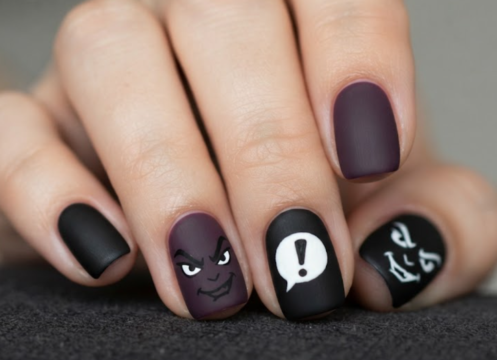 In this image, black and purple comic nails feature an evil cartoon face and dramatic speech bubbles.