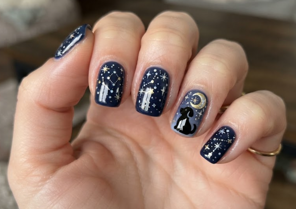 In this image, cartoonish black dog silhouette nails with moon and stars