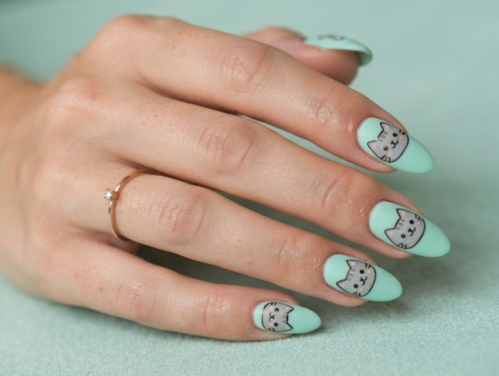 In this image, mint green nails with cute gray cartoon cat faces
