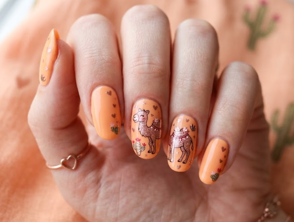 In this image, apricot nails with a rose gold cartoon camel and hearts