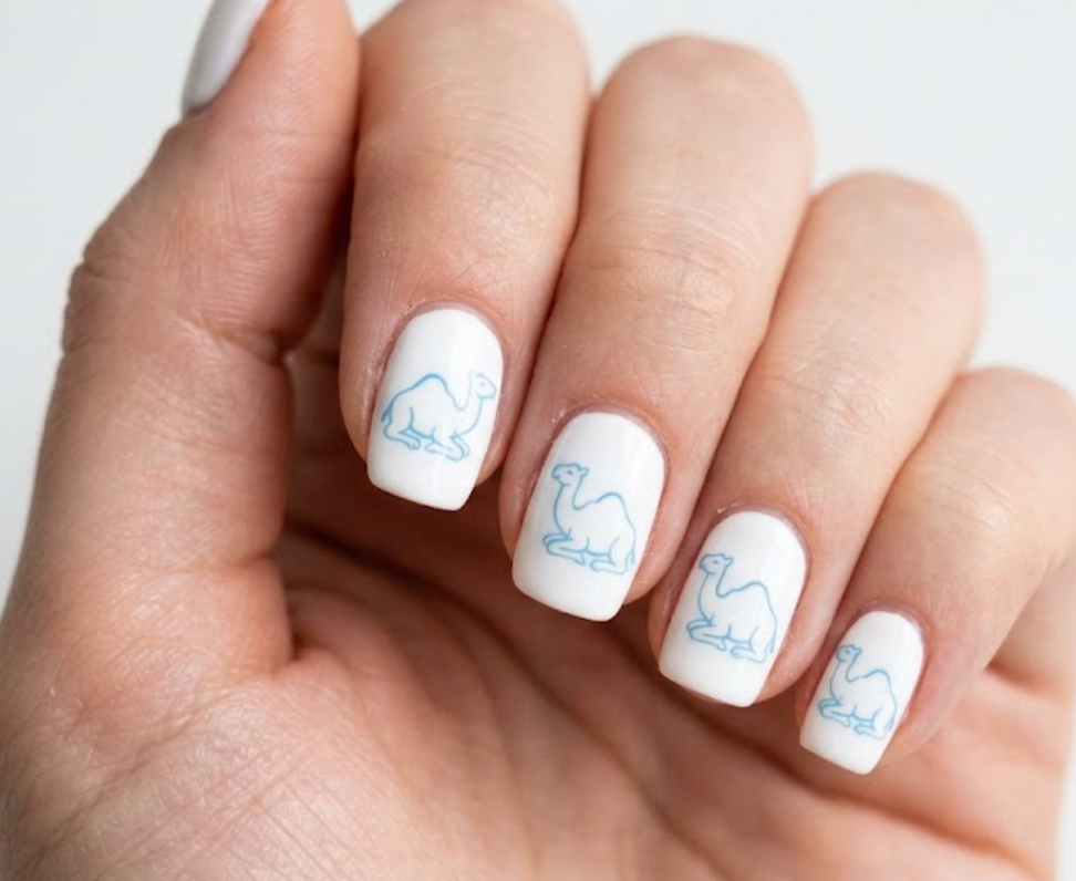 In this image, white nails with a sky blue minimalist cartoon camel