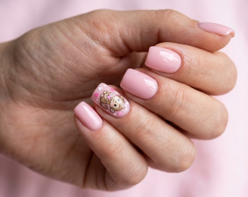 In this image, soft pink nails with an adorable baby cartoon monkey